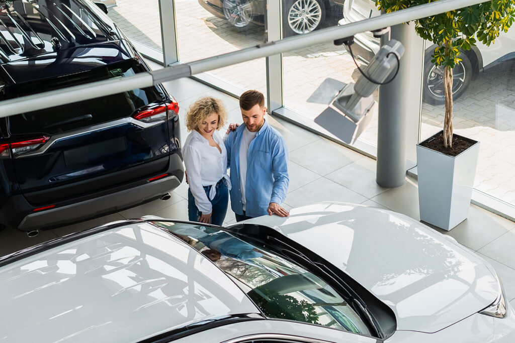 man and woman in a car dealership
